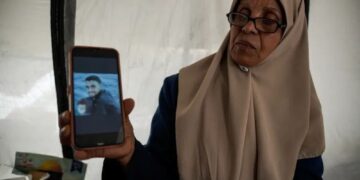 INAAM memegang gambar anak sulungnya yang ditahan oleh Israel, Mahmoud, di khemahnya di Gaza City. 
–  AGENSI