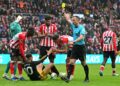 Pengadil perlawanan, Stuart Attwell  (kanan) melayangkan kad kuning kepada penyerang Manchester United, Matheus Cunha dalam aksi Liga Perdana Inggeris menentang Sunderland di Stadium of Light, Sunderland, hari ini. - AFP