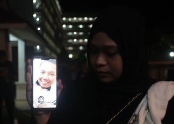 NURKHAERYNA Dhania Azreen Khairil Azri menunjukkan gambar arwah suaminya yang terlibat dalam nahas kemalangan melibatkan tali bot yang terputus ketika latihan kecemasan di perairan Terengganu-Pahan  ketika ditemui di Jabatan Forensik Hospital Sultanah Nir Zahirah (HSNZ) Kuala Terengganu, Terengganu. -UTUSAN/PUQTRA HAIRRY