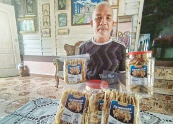 KHAIRUDDIN Saad menunjukkan rempeyek menggunakan resepi Allahyarham isterinya di rumahnya di Kampung Seri Kenangan, Setiu, Terengganu. - UTUSAN/WAN ZURATIKAH IFFAH WAN ZULKIFLI