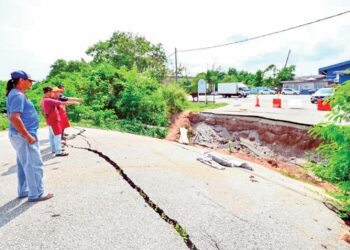 WAKIL penduduk dan peniaga melihat keadaan jambatan yang runtuh dan belum dibaiki sejak enam bulan lalu di Taman Shahzan di Kuantan, Pahang. – UTUSAN/SHAIKH AHMAD RAZIF