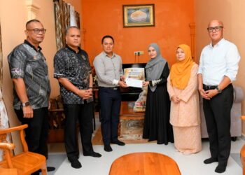 FADZLI Adam (tiga dari kiri) menyampaikan sumbangan takaful kepada Nik Norazita (tiga dari kanan)  di Kampung Baru Gong Badak, Simpang Tok Jembal, Kuala Nerus, Terengganu.