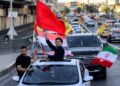DUA lelaki mengibarkan bendera Iraq, Iran, Lubnan dan Hizbullah di Baghdad, susulan pengumuman perjanjian menamatkan perang antara Iran dan Amerika Syarikat (AS).- AFP