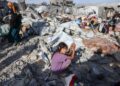 PENDUDUK Palestin mengutip barang keperluan mereka di lokasi serangan udara Israel di kem perlindungan Khan Younis, selatan Semenanjung Gaza.- AFP