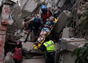 ANGGOTA penyelamat mengusung mangsa dari bangunan yang runtuh akibat gempa bumi berkembar di Caracas kelmarin.- AFP