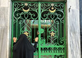 SEORANG wanita melihat pintu pagar besi semasa sambutan Tahun Baharu Hijrah di Masjid Ibrahimi, dikenali sebagai Gua Patriark, yang terletak di dalam sektor H2 di bawah kawalan Israel di bandar Hebron, Tebing Barat.- AFP