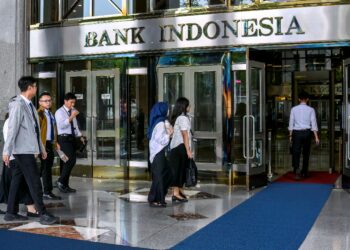 SEKUMPULAN pelatih berjalan menuju pintu masuk Bank Indonesia di Jakarta.- AFP