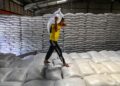 PEKERJA membawa seguni beras di gudang Biro Logistik Indonesia (BULOG) di Lambaro, wilayah Aceh.- AFP