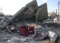 SEORANG budak duduk atas kerusi di tepi runtuhan bangunan di Gaza. - AFP