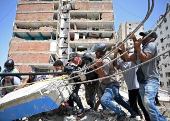 SUKARELAWAN cuba mengalihkan serpihan ketika mencari mangsa di bawah runtuhan bangunan di Catia La Mar, La Guaira, di Venezuela kelmarin.- AFP