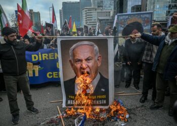 PENUNJUK perasaan membakar poster Perdana Menteri Israel, Benjamin Netanyahu, ketika protes membantah serangan AS-Israel ke atas Iran di Istanbul pada 1 Mac lalu.- AFP