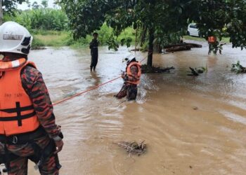 ANGGOTA bomba menggunakan sistem keselamatan tali untuk menyeberangi kawasan ditenggelami air di Kampung Permatang Keramat, Jalan Batu Hampar di Yan. - IHSAN BOMBA