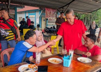 AMINUDDIN Harun menyantuni orang ramai di Dataran Tanjung Agas, Port Dickson, Negeri Sembilan yang terletak dalam kawasan DUN Linggi, semalam.
