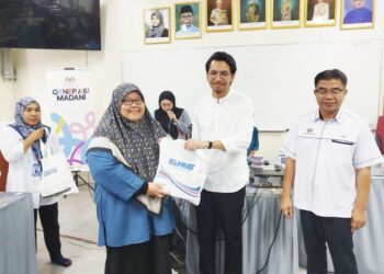 MUHAMMAD Kamil Abdul Munim menyampaikan cenderamata kepada wakil agensi kerajaan yang hadir dalam majlis di SMK Tun Perak Padang Rengas, Perak hari ini. - UTUSAN/FADZIL ZAINOL
