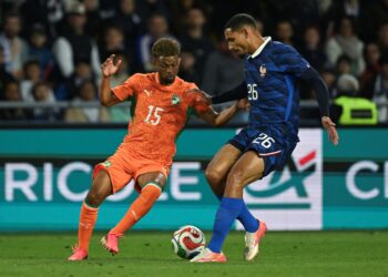 PENYERANG Ivory Coast, Amad Diallo cuba melepasi benteng Perancis, Maxence Lacroix ketika kedua-dua pasukan itu bertemu dalam satu aksi persabahatan di Stade de la Beaujoire, Nantes, Perancis, semalam. - AFP