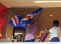 Ana Candida Evora (tengah) mengibarkan bendera Cape Verde ketika menyaksikan perlawanan menentang Uruguay di Stadium Miami, semalam. - AFP