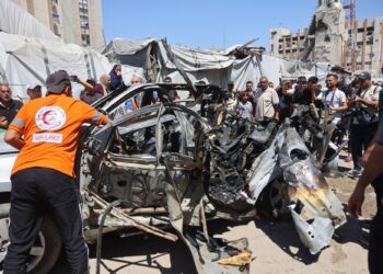 Pasukan penyelamat dan penduduk Palestin memeriksa kereta mangsa yang menjadi sasaran serangan bom oleh tentera Zionis di Gaza semalam. – AFP