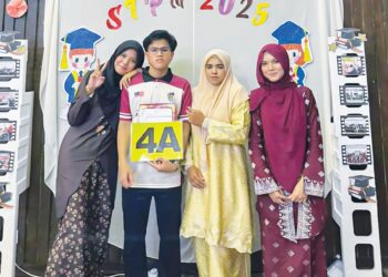 IRFAN Nazmi Ahmad Fakharuddin bersama Robiah Wahab (dua dari kanan) dan dua orang adiknya menunjukkan slip keputusan PNGK 4.0 peperiksaan  STPM di Sekolah Menengah Kebangsaan (SMK) Dong di Raub, Pahang.