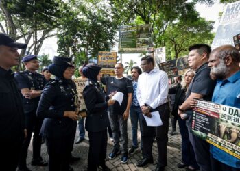 Rajesh Nagarajan (tengah) menyerahkan memorandum menuntut siasatan berhubung pemindahan tiga gajah tempatan (Dara, Amoi dan Kelat) ke sebuah zoo di Jepun kepada wakil Ketua Polis Negara, ASP Norbariah Fazuan Ramli di hadapan Ibu Pejabat Polis Bukit Aman, semalam. UTUSAN/ MUHAMAD IQBAL ROSLI