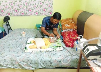 MOHD. Latfi Baharom memeriksa tiub mesin oksigen yang digunakan bayinya, Muhammad Luqman semasa ditemui di rumah mertuanya di Kampung Batu 2, Jalan Jeniang, Gurun di Sungai Petani, Kedah.