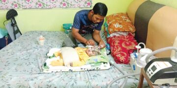 MOHD. Latfi Baharom memeriksa tiub mesin oksigen yang digunakan bayinya, Muhammad Luqman semasa ditemui di rumah mertuanya di Kampung Batu 2, Jalan Jeniang, Gurun di Sungai Petani, Kedah.