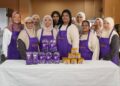 SARASVATHY Periyasamy (depan, tiga dari kanan) dan Nur Sharzi Bashar (depan, dua dari kiri) bersama komuniti setempat dalam program Kuih Raya Dari Hati bersama Cadbury.