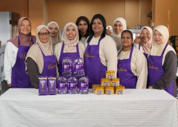 SARASVATHY Periyasamy (depan, tiga dari kanan) dan Nur Sharzi Bashar (depan, dua dari kiri) bersama komuniti setempat dalam program Kuih Raya Dari Hati bersama Cadbury.