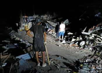 LAMPU sebuah trak pikap digunakan bagi mencari mangsa gempa bumi di Caraballeda. - AFP