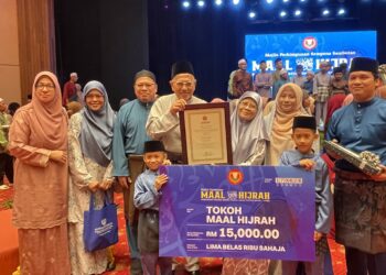 SHUKRI Abdullah (tengah) disamping isterinya, Khadijah Zakaria dan anak-anak serta cucu mereka selepas menerima anugerah Tokoh Maal Hijrah peringkat negeri Kedah dalam sambutan di Wisma Darul Aman, Alor Setar.