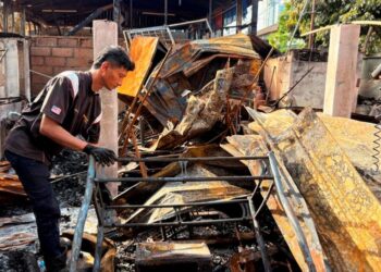 MOHD. Khairul Azwan Anuar melihat kebakaran rumahnya 
di Kampung Gok Kapur Kota Bharu, Kelantan, semalam. 
– UTUSAN/ ROSLIZA MOHAMED