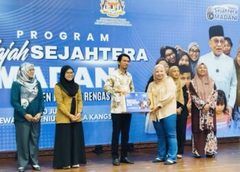 MUHAMMAD Kamil Abdul Munim (tengah) menyampaikan komputer riba kepada pelajar cemerlang Sijil Pelajaran Malaysia (SPM) semasa Program Jelajah Sejahtera Madani di Padang Rengas, Perak hari ini. - UTUSAN/FADZIL ZAINOL