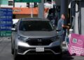 GAMBAR fail seorang lelaki bersiap sedia mengisi petrol. - AFP