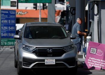 GAMBAR fail seorang lelaki bersiap sedia mengisi petrol. - AFP