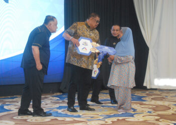 Ab. Rauf Yusoh menyerahkan replika kunci rumah PMR kepada seorang penerima pada Majlis Perhimpunan Bulanan Pentadbiran Kerajaan Negeri Melaka bagi Jun 2026 di MITC, Ayer Keroh, hari ini. - UTUSAN/AMRAN MULUP