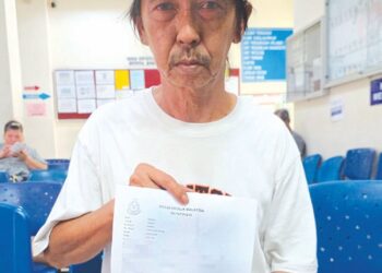 HASZMAN Othman menunjukkan laporan polis dibuat terhadap individu di media sosial yang memfitnah dan mengaibkan isterinya, Jaslinda Saludin di IPD Tapah kelmarin.