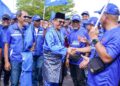 BAHARUDIN Mohamed Taib (tengah) menyantuni penyokong BN yang mengiringi beliau menuju ke Pusat Penamaan Calon DUN Permas Di Dewan Muafakat Taman Mawar, Pasir Gudang.