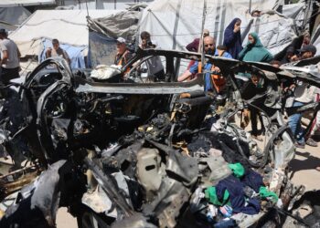 Rakyat Palestin berkumpul di lokasi sebuah kenderaan yang menjadi sasaran serangan udara Israel di Bandar Gaza pada 18 Jun 2026. -  AFP