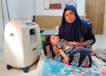 SUHANA Rajab meriba Nik Mohammad Nasrulhaq Nik Mohd. Zakwan yang bergantung kepada mesin oksigen untuk bernafas ketika ditemui di Kampung Gong Lilit, Besut, Terengganu.