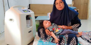 SUHANA Rajab meriba Nik Mohammad Nasrulhaq Nik Mohd. Zakwan yang bergantung kepada mesin oksigen untuk bernafas ketika ditemui di Kampung Gong Lilit, Besut, Terengganu.