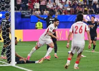 PERTAHANAN Turkiye, Kaan Ayhan (tengah) meraikkan jaringan ketiga pasukannya ketika menentang Amerika Syarikat di Stadium Los Angeles, hari ini.-AFP