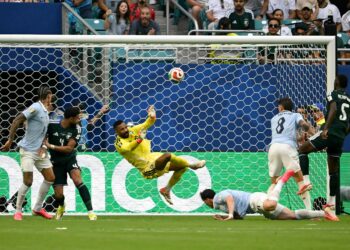 Penjaga gol Arab Saudi, Mohammed Al-Owais menumbuk keluar bola ketika diasak pemain Uruguay pada aksi Kumpulan H Piala Dunia 2026 di Stadium Miami, awal pagi tadi, dengan aksi cemerlangnya membantu Green Falcons mengikat juara dunia dua kali itu 1-1. – AFP
