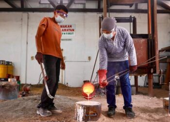 NAJIB Rusyaidi Rosli (kiri) bersama Shaiful Sani Zakaria menghasilkan produk tembaga di bengkel Perbadanan Kemajuan Kraftangan Malaysia Cawangan Terengganu di Chendering, Kuala Terengganu, Terengganu. – UTUSAN/PUQTRA HAIRRY
