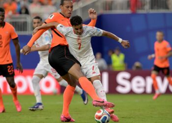 PERTAHANAN Belanda, Virgil van Dijk mengasak penyerang Tunisia, Elias Achouri pada aksi terakhir Kumpulan F di Kansas City, hari ini.-AFP