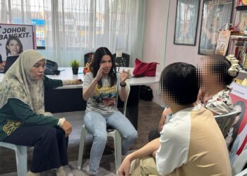 MARINA Ibrahim (tengah) menyantuni penduduk setempat yang hadir ke pejabatnya selaku ADUN Skudai.