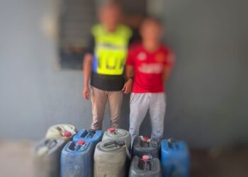 ANGGOTA PGA (kiri) bersama suspek yang ditangkap selepas disyaki menyeludup petrol ke Thailand di di pangkalan haram Zink Merah, Lubok Gong, Rantau Panjang, Kelantan hari ini.