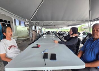 HASZMAN Othman (kiri) bersama kakak dan abang Jaslinda Saludin
ketika ditemui di Tapah, Perak semalam.