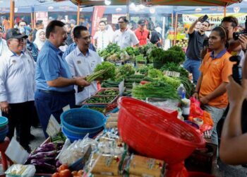 AMIR Hamzah Azizan beramah mesra dengan peniaga sayur pada Program Lawatan Pasar Tani di Kelana Jaya, Petaling Jaya, Selangor, hari ini. - UTUSAN/SHIDDIEQIIN ZON