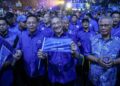 HISHAMMUDDIN Hussein (tengah) mengibarkan bendera Barisan Nasional semasa menghadiri Majlis Pelancaran Jentera Barisan Nasional Negeri Johor di Stadium Tertutup Kompleks EduCity, di sini hari ini.
