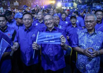 HISHAMMUDDIN Hussein (tengah) mengibarkan bendera Barisan Nasional semasa menghadiri Majlis Pelancaran Jentera Barisan Nasional Negeri Johor di Stadium Tertutup Kompleks EduCity, di sini hari ini.