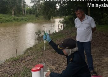 PEGAWAI JAS Kelantan mengambil sampel air untuk dianalisis susulan kematian ratusan ekor ikan di Kampung Alor Pasir, Tanah Merah, Kelantan.-IHSAN JAS KELANTAN.